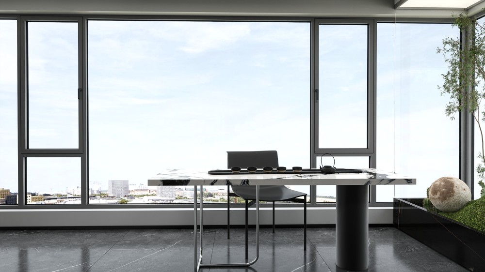 Residential workspace with a desk and laptop beside dark-framed windows